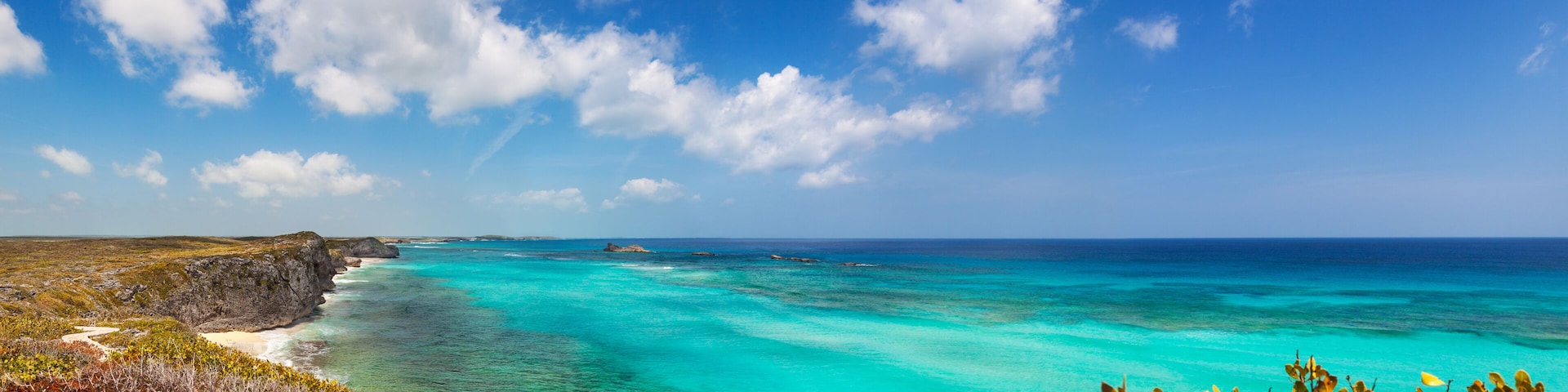 Panoramic view of the cliffs, reef and turquoise shallows at Mudjin Harbor, Middle Caicos