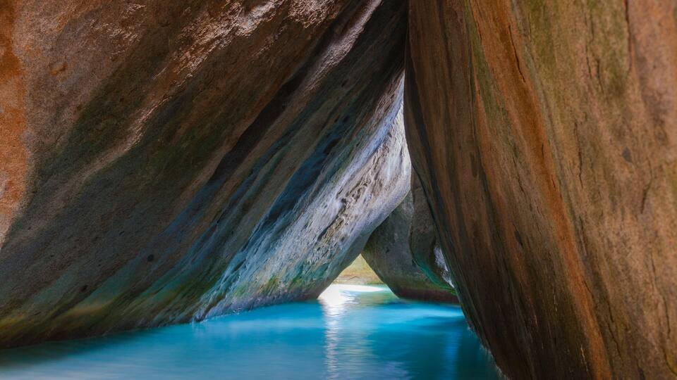 A natural rock formation with a clear blue water channel running through it.