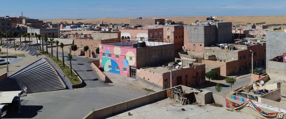 The view from our residence. Laâyoune with the desert in the background. The brightly painted building is the local school. #FindingTheUniverse #Morocco #Morac #WesternSahara
