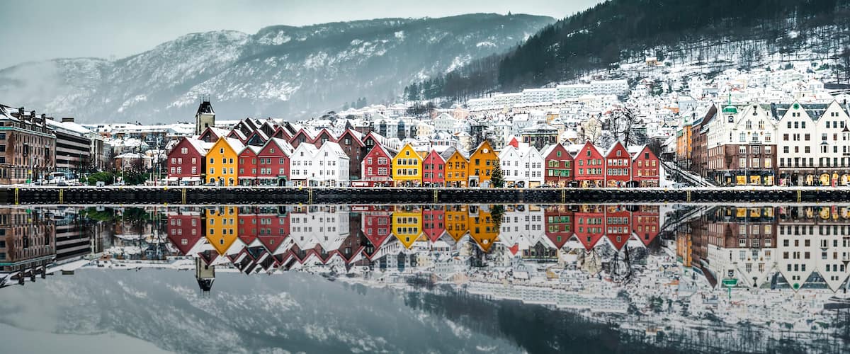 A snowy town with colorful houses and a mountain in the background.