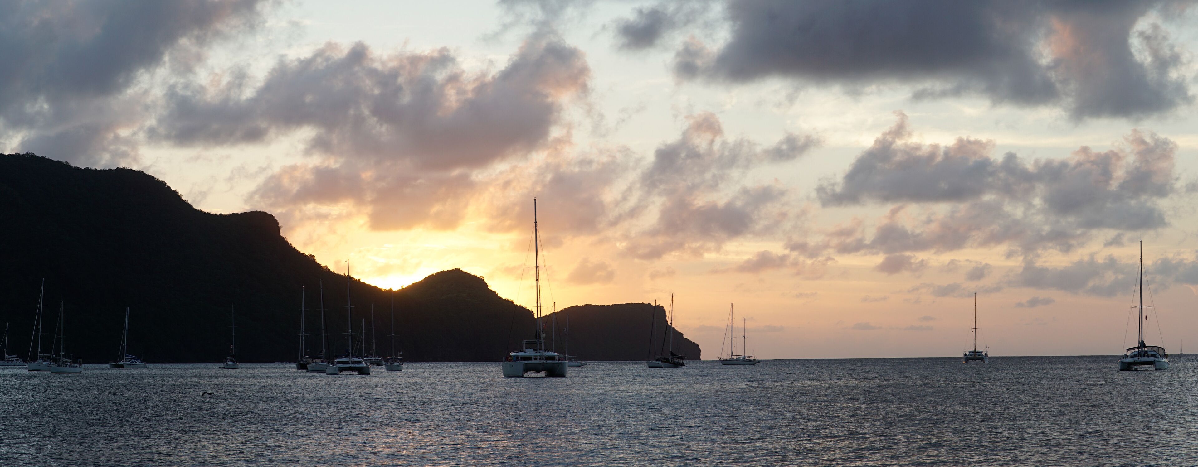 Sunset over Union Island with Sail boat yachts in the Tobago Cays near Saint Vincent and the Grenadines, Caribbean.
