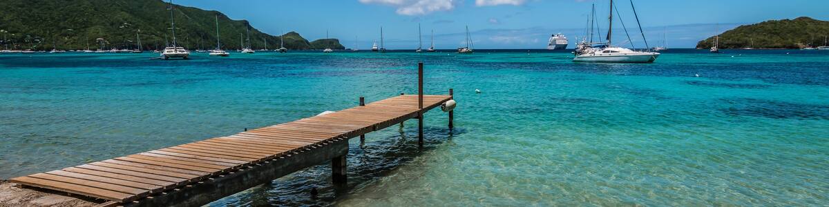 Panoramic sea and harbor view with wooden pier at the beach of Bequia, St Vincent and the Grenadines.