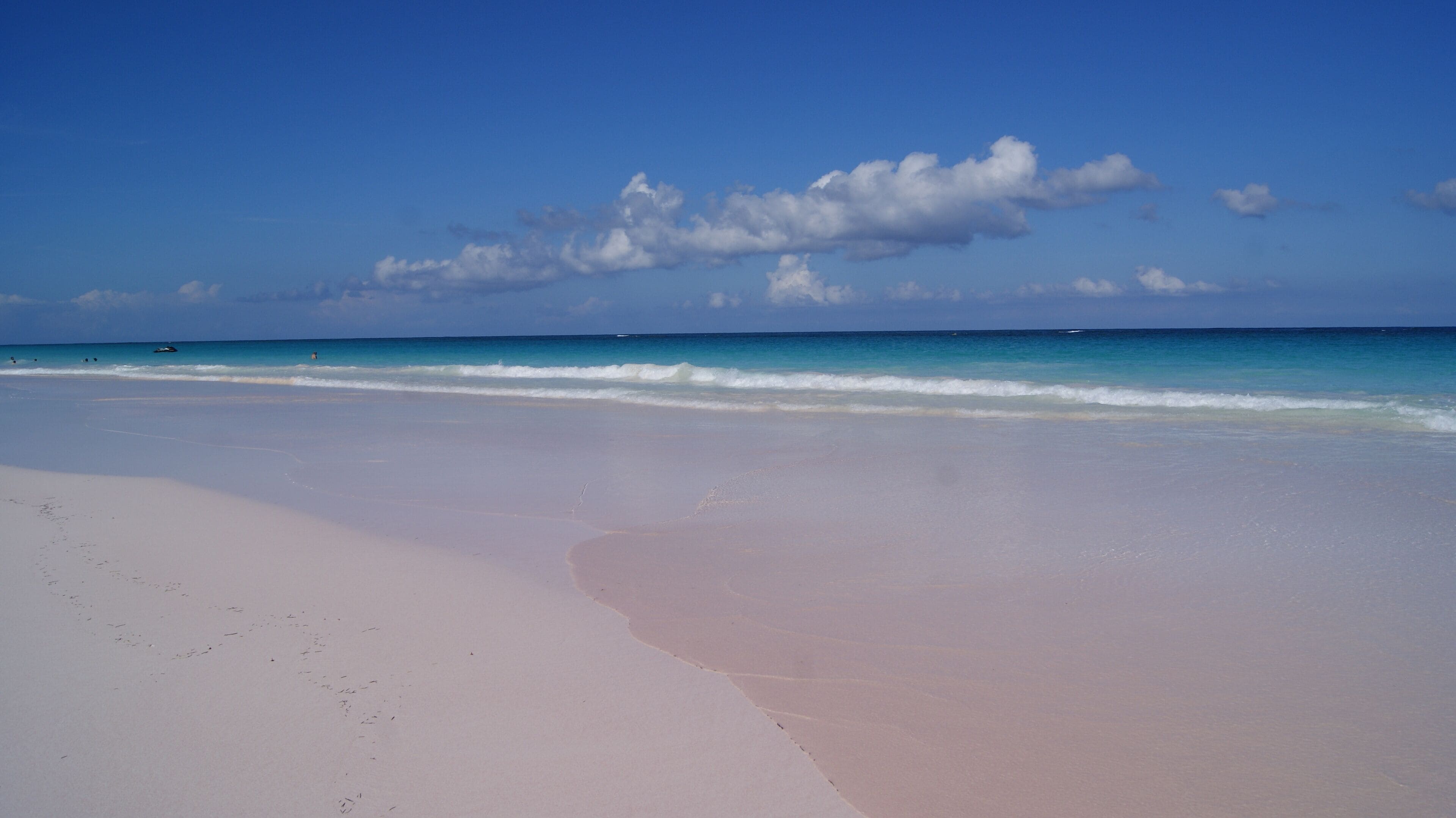 A beach with a clear sky and gentle waves.