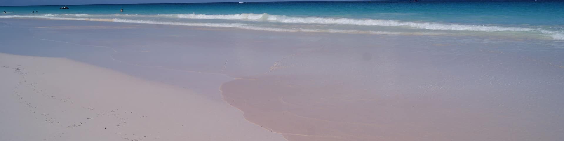 A beach with a clear sky and gentle waves.
