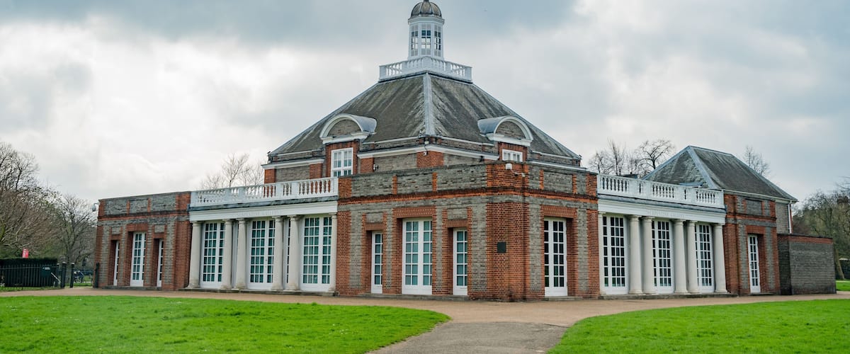 A large brick building with a central dome and a smaller dome on the right.