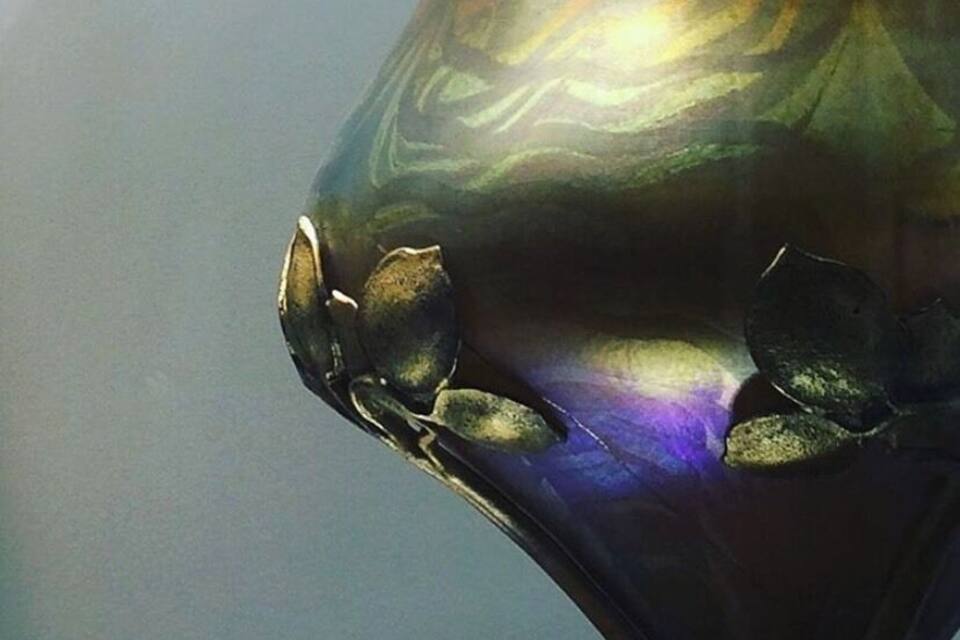 A metallic sculpture with a reflective surface and floral patterns.