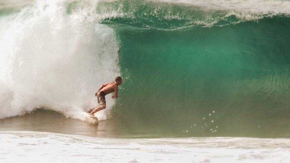 Un surfista cabalgando una ola grande en el océano.