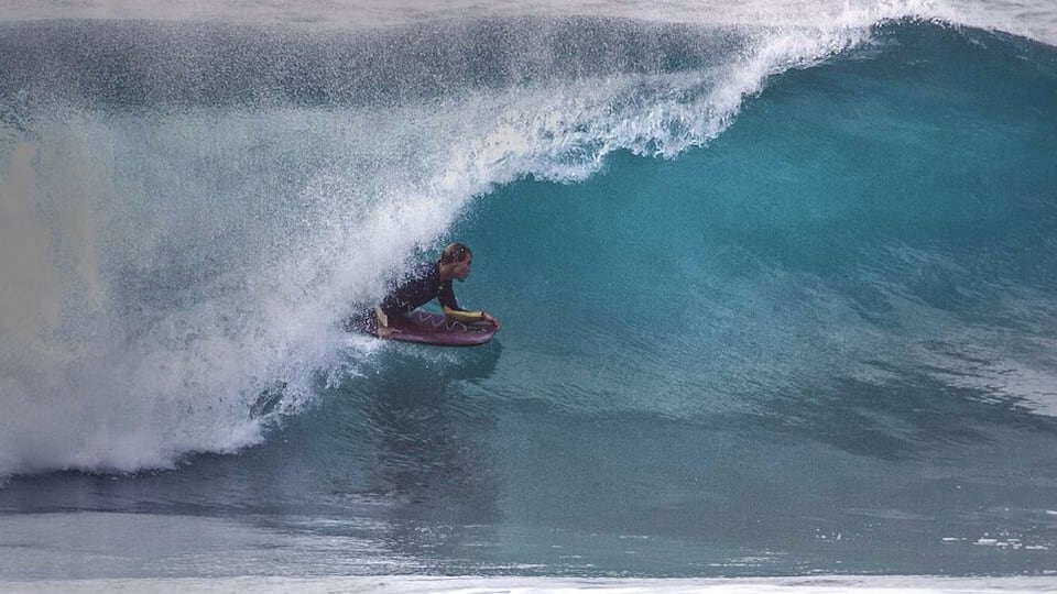 A surfer riding a large wave.