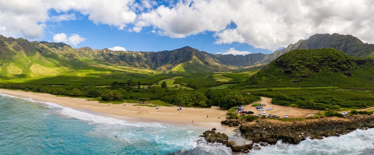 Broad panorama of Makua beach and valley from aerial view over the ocean on west coast of Oahu, Hawaii