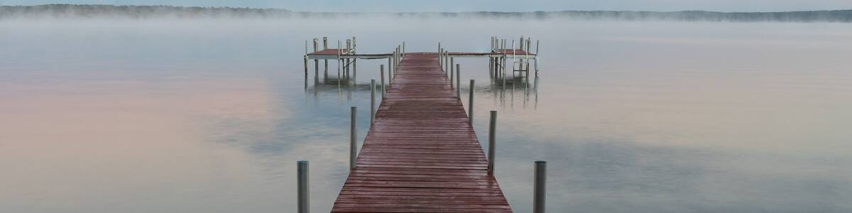 Dock on Mullett Lake in Indian River Michigan with pastel skies overhead
