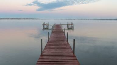 Dock on Mullett Lake in Indian River Michigan with pastel skies overhead