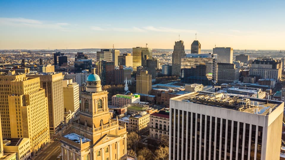 A cityscape with a mix of historic and modern buildings, including a prominent dome and a tall skyscraper.
