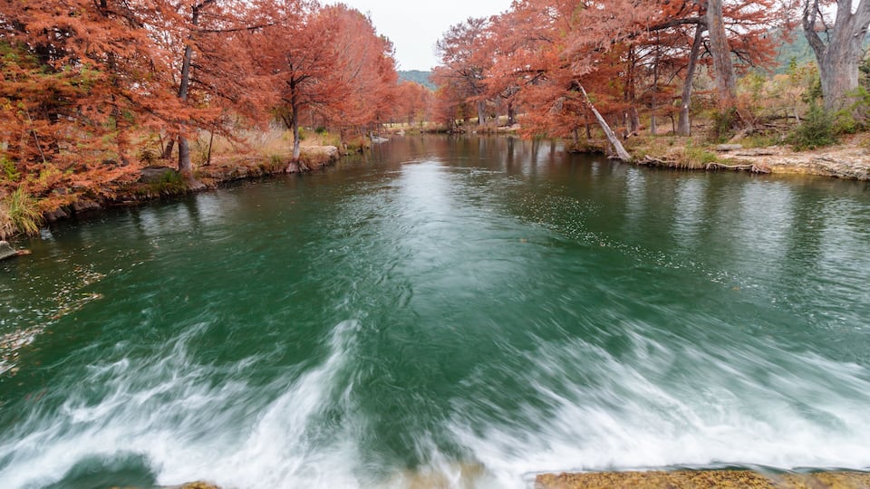 A river with autumn-colored trees on both sides.