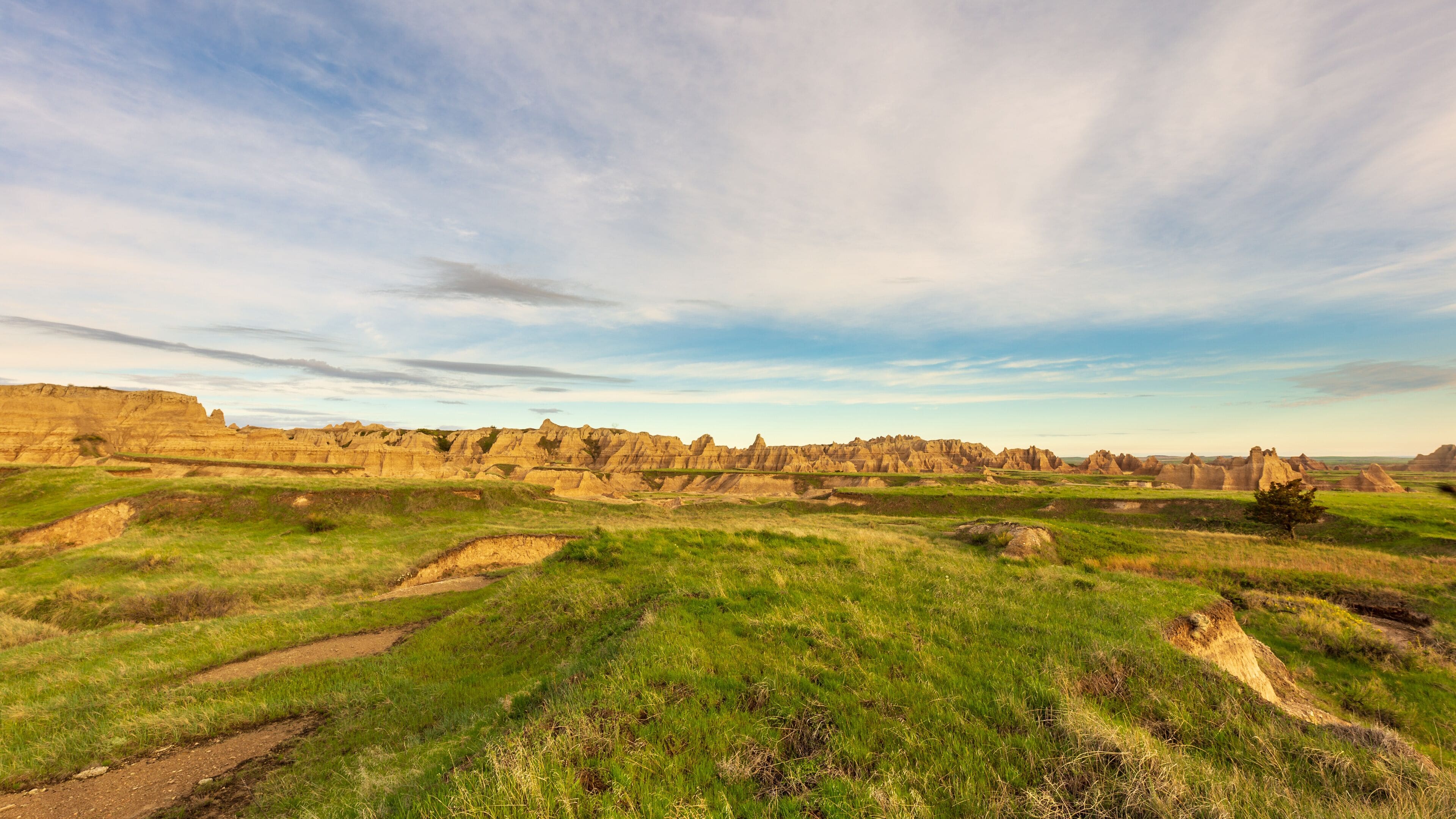 Morning breaks over the hills and grassland of Badlands National Park on Notch Trail