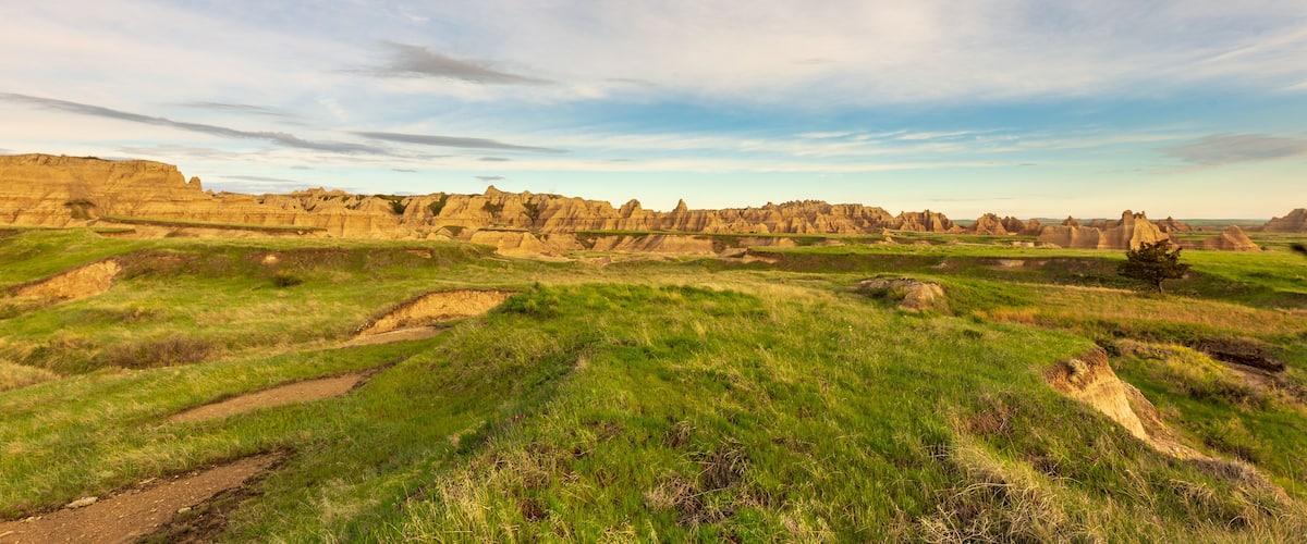 Morning breaks over the hills and grassland of Badlands National Park on Notch Trail
