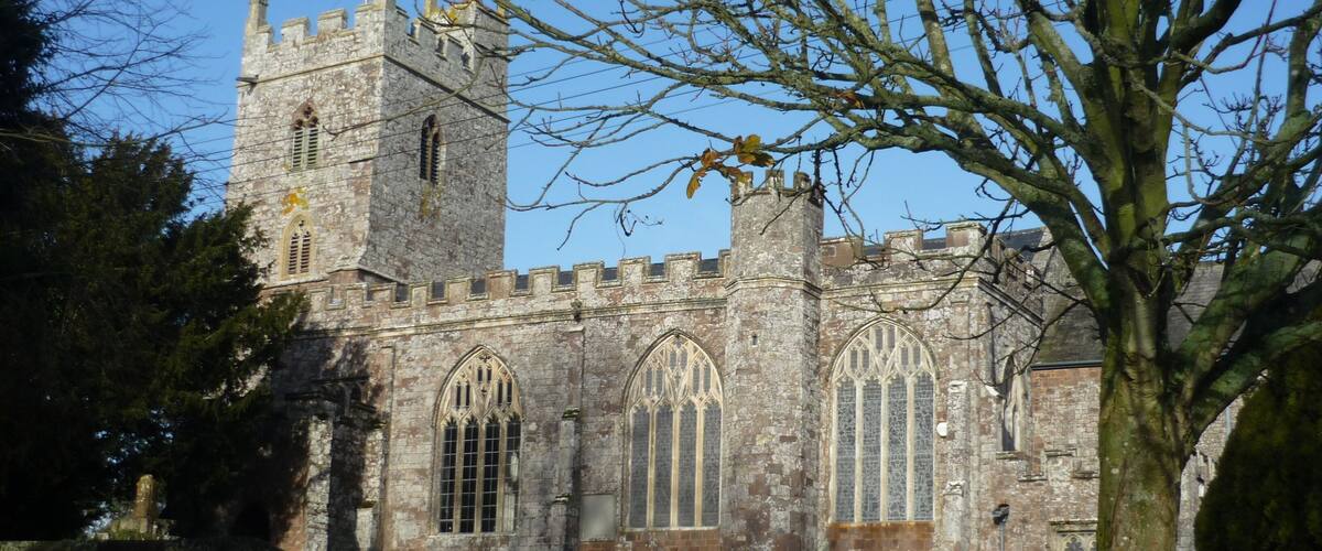 A historic stone church with a tall tower and arched windows.