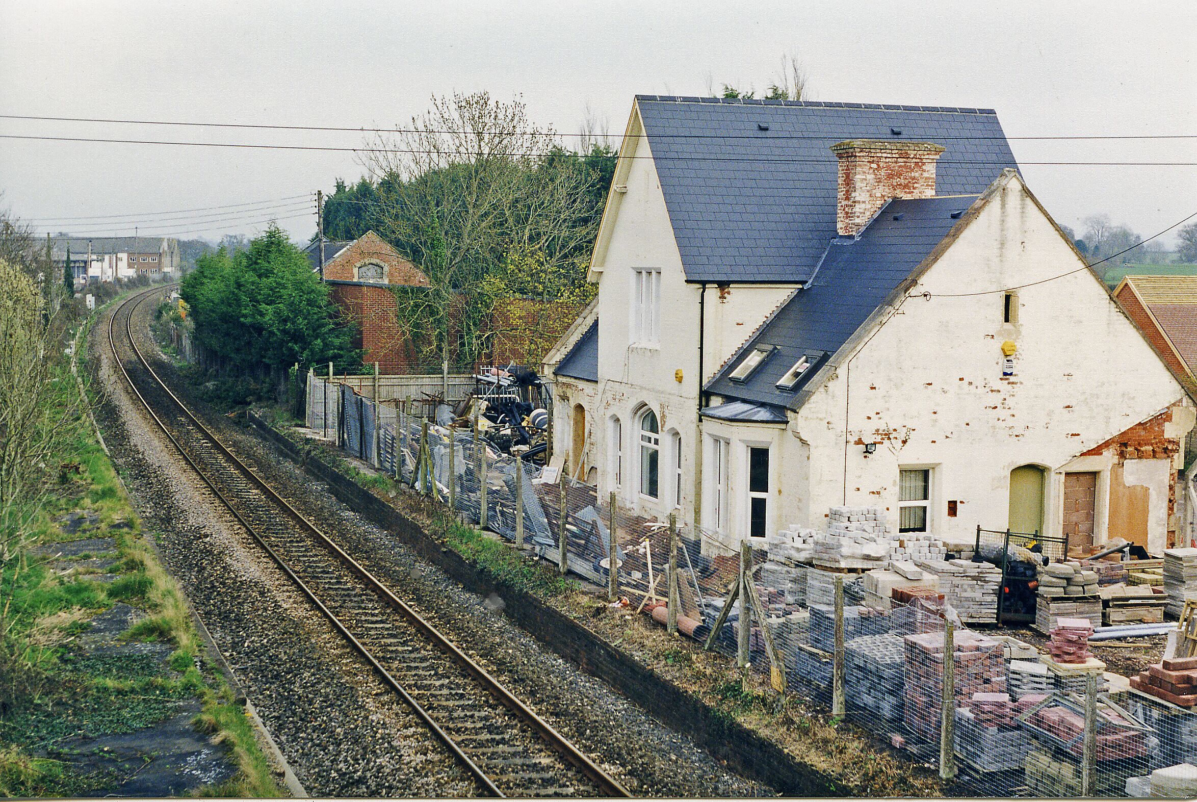Broad Clyst station (remains), 1998. View NE, towards Salisbury: ex-LSWR London - Salisbury - Exeter etc. main line. The station was closed 7/3/66 but the line remains very much in use, albeit much of it reduced to single line.