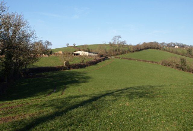 Farm buildings, Easternhill A group of outbuildings a little south of the farm at Easternhill. Doddiscombsleigh Footpath 2 follows the track along the edge of the field, before turning left behind the barns to keep to the left of the field boundary above them. The building at extreme right is a timber yard in SX8588.
