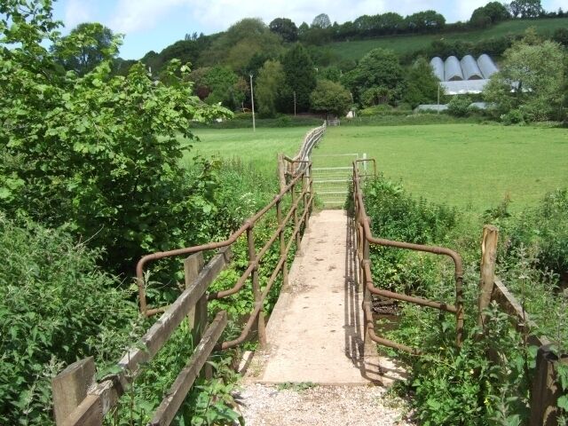 Footbridge over the Alphin Brook Part of the Exeter Green Circle footpath. In the distance there are polytunnels on a fruit farm.