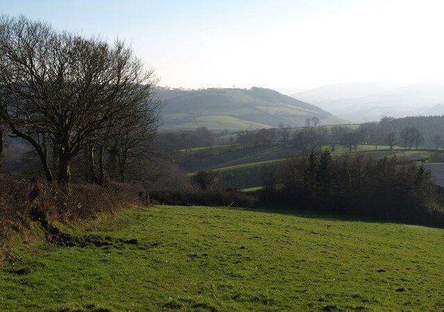 From above Easternhill Farm. Doddiscombsleigh Footpath 2 runs along the left side of this field. The farm buildings shown in 690268 are on the right. The view beyond is down the Batt's Brook valley as it makes it way towards the Teign valley in the distance.
