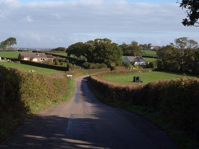 Approaching Hittisleigh. Taken a little further down the lane shown in 1551643. The group of buildings forms a separate southwest part of the scattered village; 991666, visible right of centre, is over 700 metres beyond them.