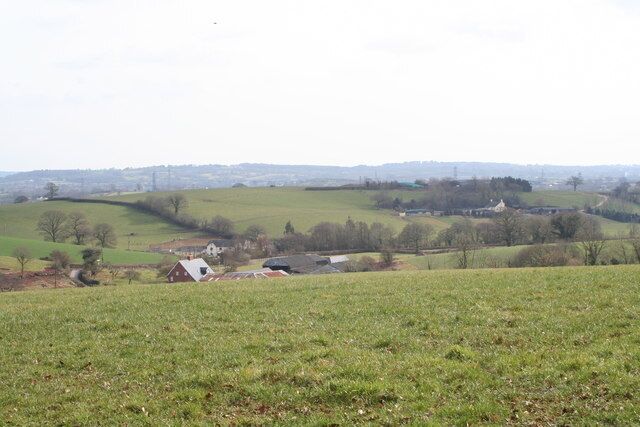 Rolling green hills, a small white house, and a distant town.