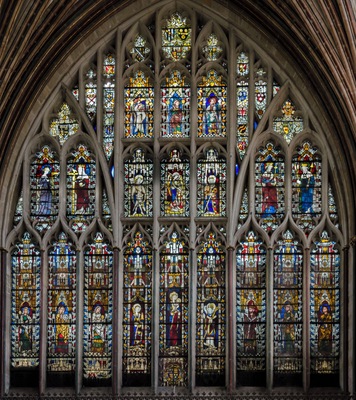 The original window was erected Circa 1300, as a six light window. When the east end of the cathedral was rebuilt, it had 3 lights added. Glazed first by Master Walter of Rouen in 1304 , it suffered a large amount of masonry decay by the 1380s and had to be remade. The new design, completed in 1390, involved carrying four central mullions to the head of the window, and adding strength by securing them with transoms. In 1391 Robert Lyen of Exeter was commissioned to glaze the new window, resetting the surviving early 14th century glass and adding new panels where needed. After the Reformation the window suffered some damage, losing several figures in its lowest and middle tiers. In the 18th century two restorations saw the introduction into the window of late medieval glass from elsewhere in the cathedral. Between 1894 and 1896 Frederick Drake, completely restored the east window glass. Between 1982 and 1986 the glass was conserved by Chapel Studios. At the top and bottom of the window there are many coats of arms. Continuing down in the middle is: Abraham, Moses, and Isaiah. The row beneath this depicts Saint Sidwell (a female Saint of Devon), St Helen, an Archangel, St Michael, St Catherine, St Edward the Confessor, and St Edmund. The main figures of the window are: St Margaret, St Catherine, Mary Magdalene, St Barbara, The Virgin and Child, St Martin, St Peter, St Paul, and St Andrew.