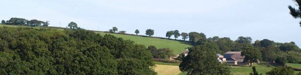 View from the cemetery, Tedburn St Mary. A view from 1492364 across a small valley that drains to the right to the Lilly Brook. On the right is Great Fairwood Farm.