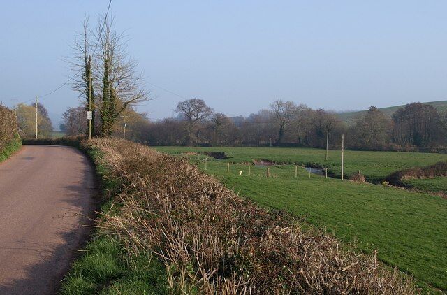 By the Kenn The River Kenn flows through a very gentle valley, and performs some wiggly little meanders just up ahead. The lane, with slight interruption to get across the A38 at Wobbly Wheel, remains close to its left bank for some 8 kilometres from Dunchideock downstream.