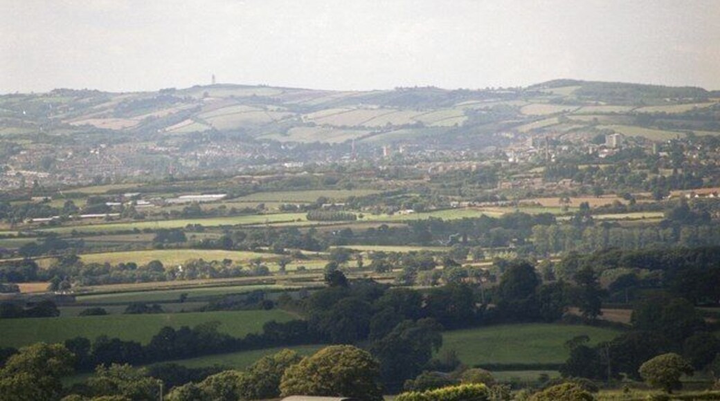 The View from Woodbury Common. Looking slightly north of west from car park W of the B3180. On the skyline is the ttransmitter tower above Redhills SX8992. In centre are Exeter Cathedral towers SX9292 and to the right Exe