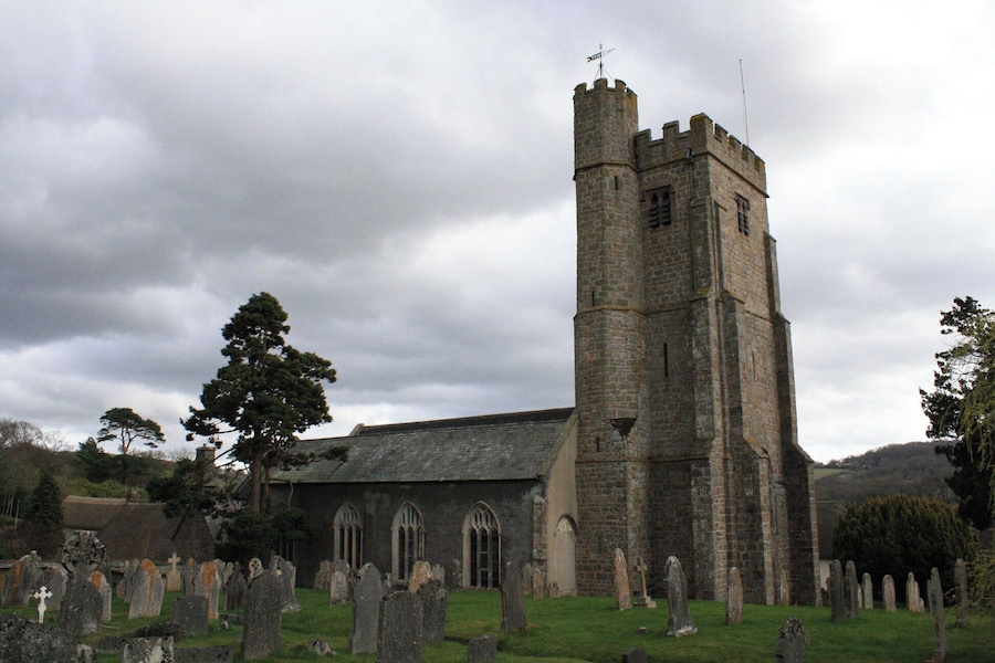 Una iglesia histórica con una torre alta y un cementerio.