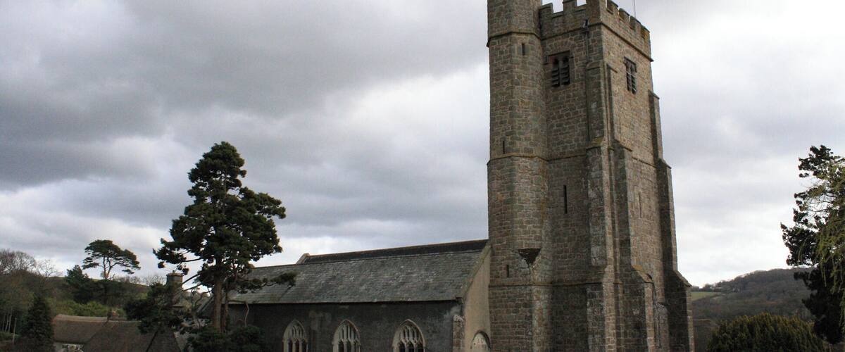 A historic church with a tall tower and a graveyard.