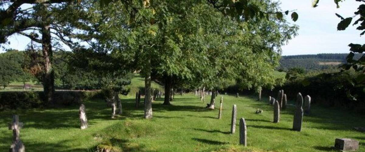 A cemetery with gravestones and trees.