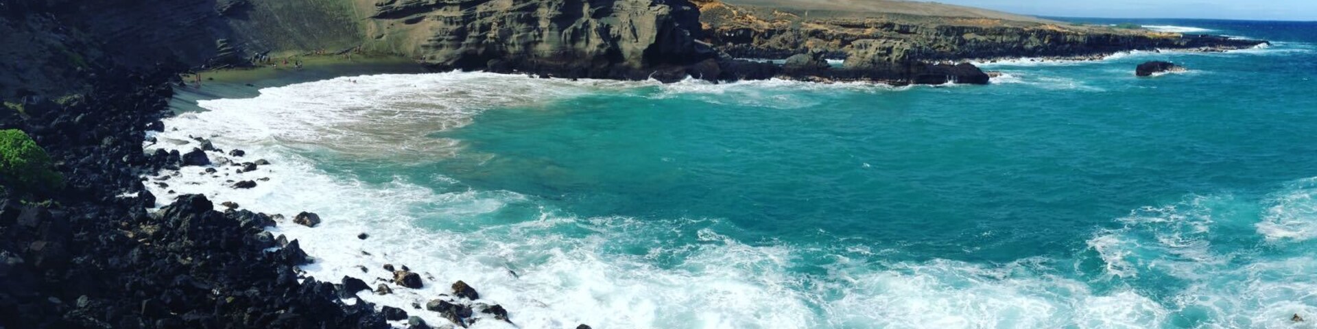Um litoral acidentado com costas rochosas e ondas quebrando nas falésias.