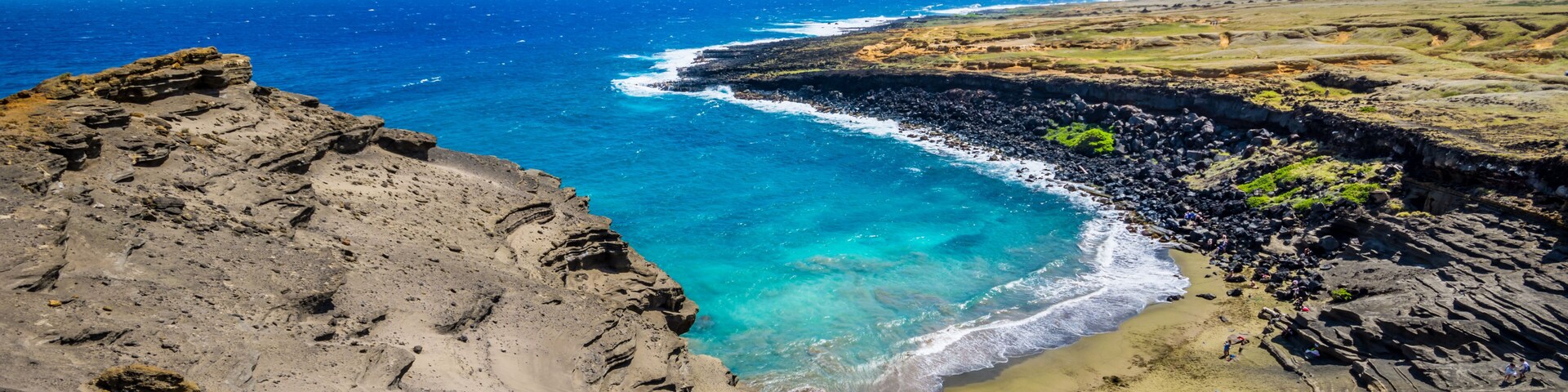 Paisaje costero con costa rocosa, aguas azules cristalinas y un horizonte lejano.