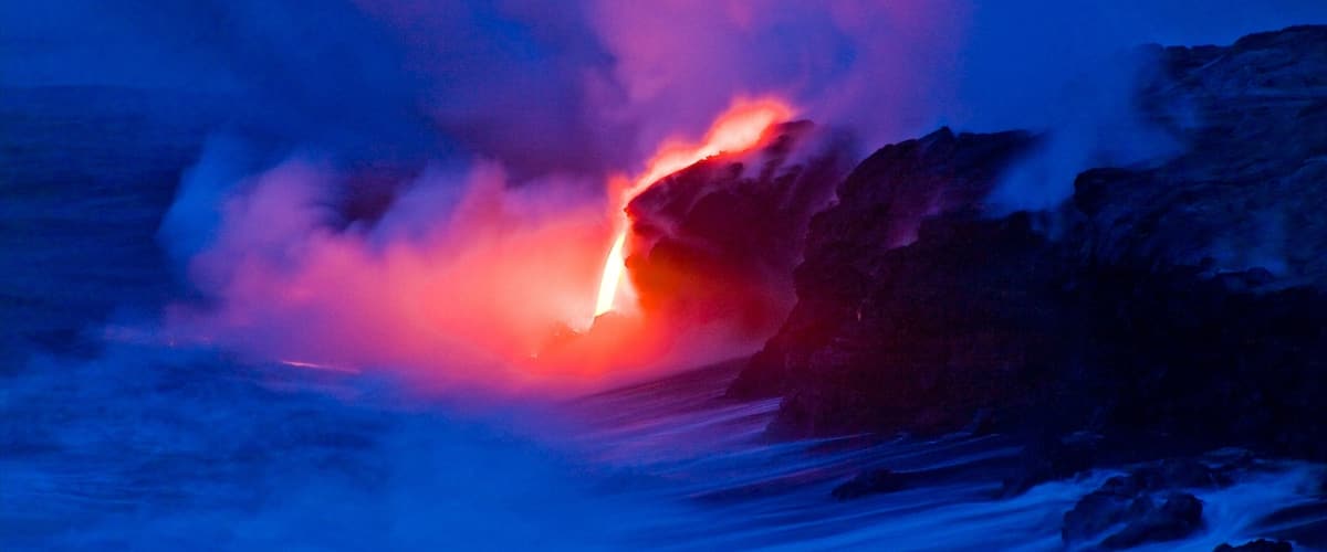 A lava flow in a dark, rocky landscape.