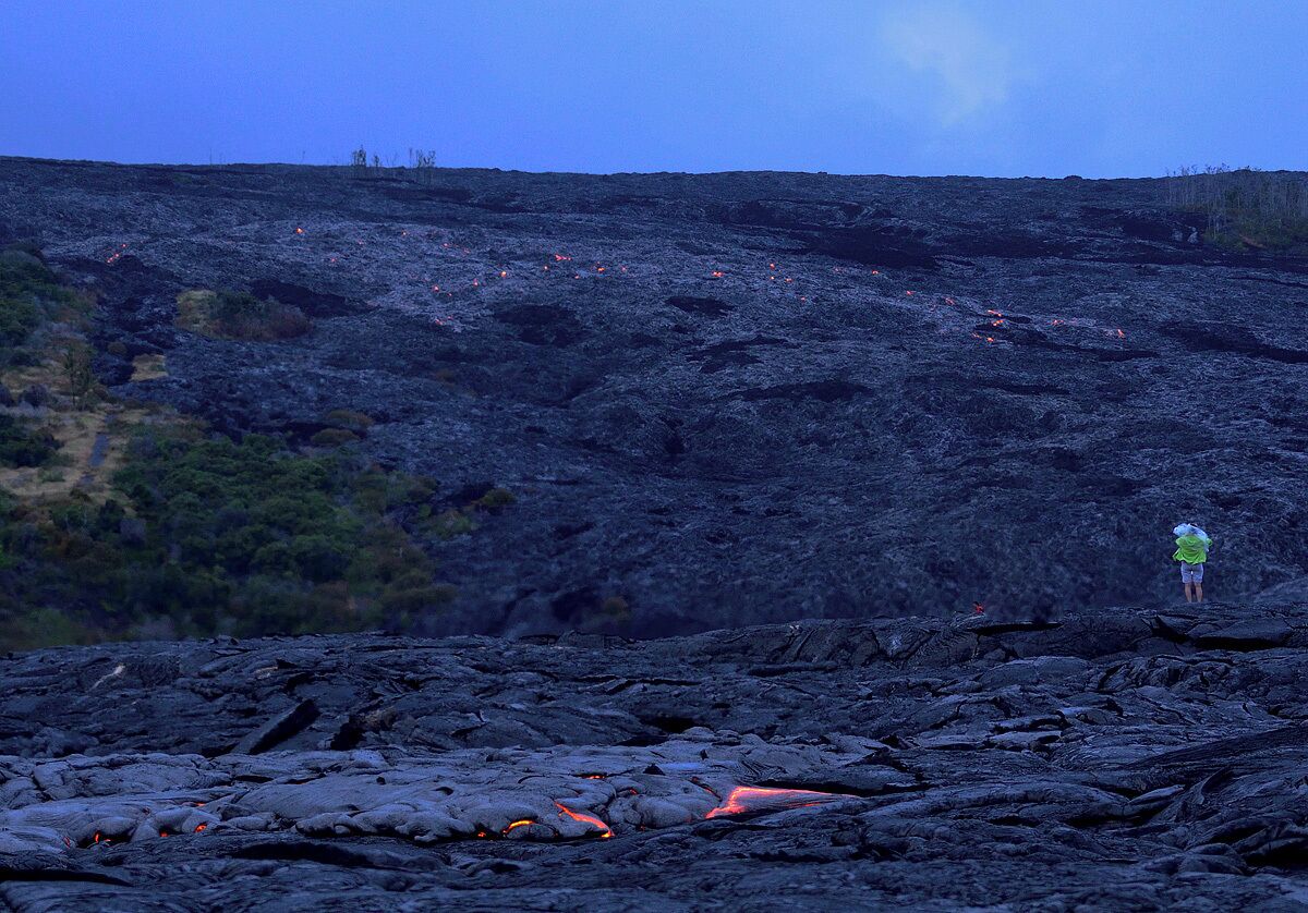 #NationalPark My wife standing near a large lava flow. Check out the lava above and beneath her. You have to respect lava if you venture into the active areas. If you slip and fall the consequences are bad. Lava reaches temperatures of 2200 degrees which will vaporize wood. It almost feels like tapioca when you put a stick in it.