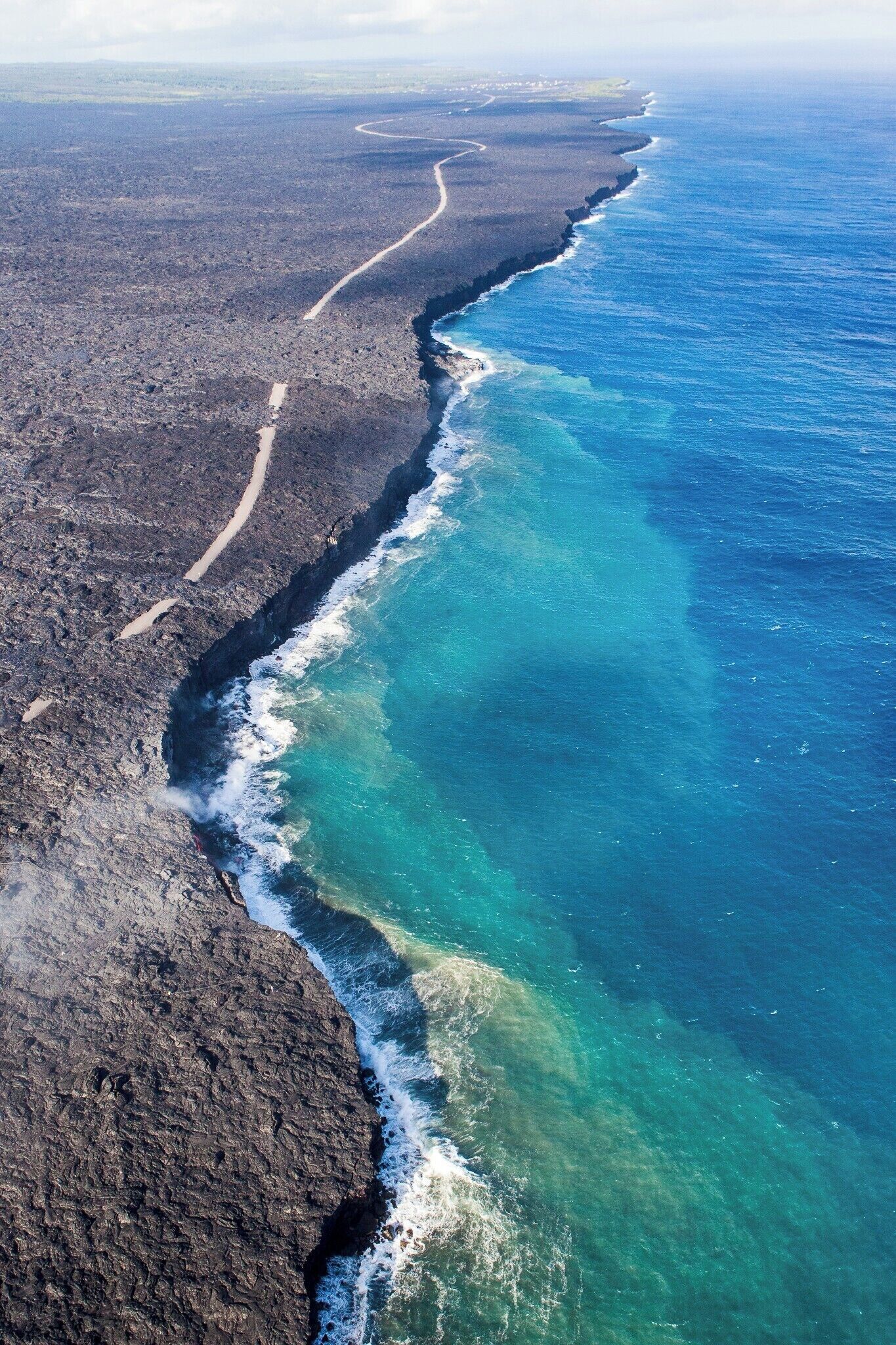 A door's off helicopter tour from Hawaii's Big Island gave me a unique perspective of the lava flow as it was just flowing into the ocean. Here you can see a little bit of the flowing lava, which is what I had wanted to see. However, what I found even more interesting, even after getting a better angle on the red lava,  was seeing the hardened lava which had overtaken the road at certain points. I particularly loved the dramatic contrast between the devastated earth and the beautiful blue water, full of so much life. 
#BVSBlue