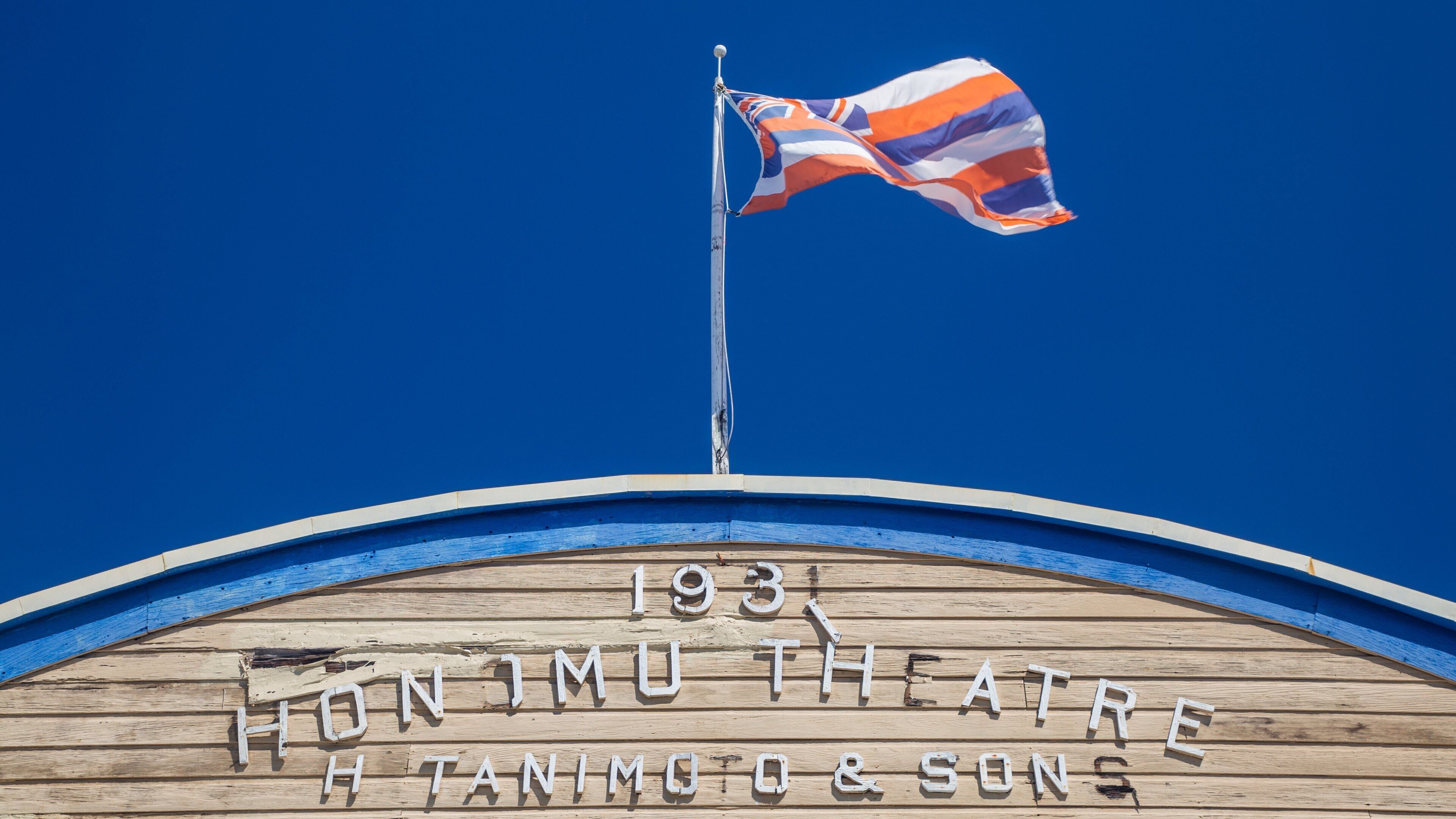 A wooden sign with "1931 HENIMOTO THEATRE" and "H. TANIMOTO & SON" written on it.