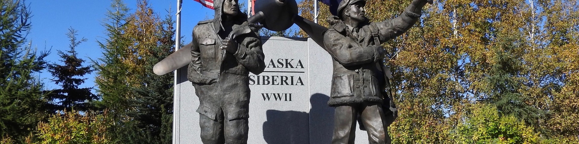Ein Denkmal mit zwei Soldaten, einer US-amerikanischen Flagge und einer Flagge der Sowjetunion.
