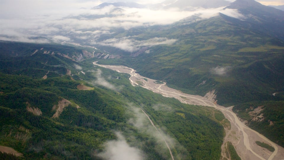 A river winding through a mountainous valley with dense forests and mist-covered peaks.