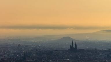 Une vue urbaine avec une cathédrale imposante et une montagne en arrière-plan.