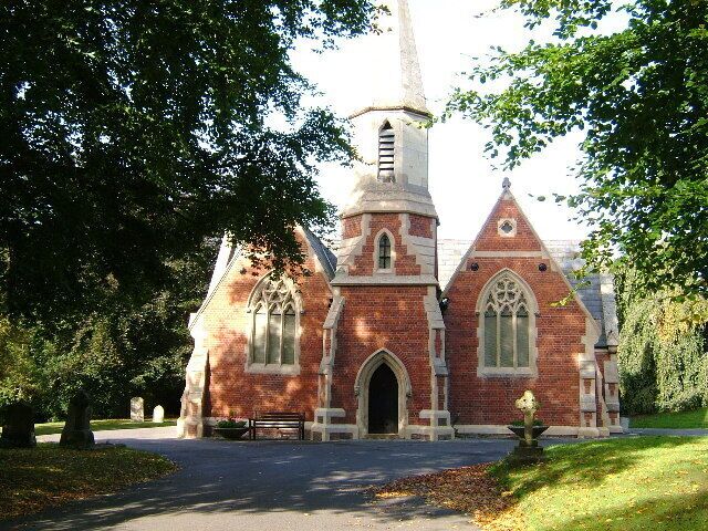 A historic brick church with a tall steeple and pointed arches.