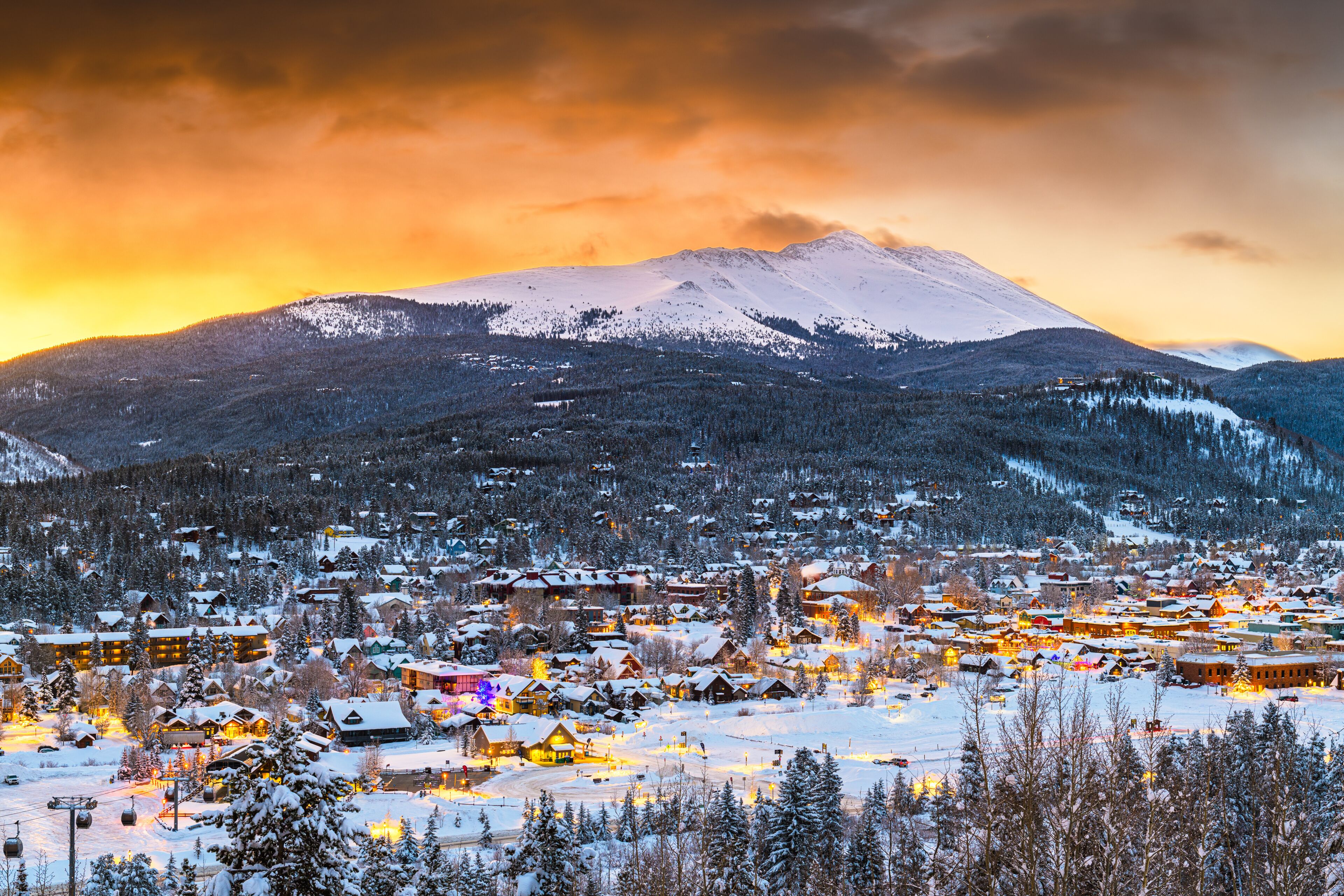 A snow-covered village with a mountain in the background.