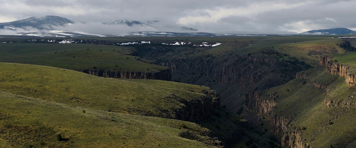 A canyon with steep cliffs and a valley.