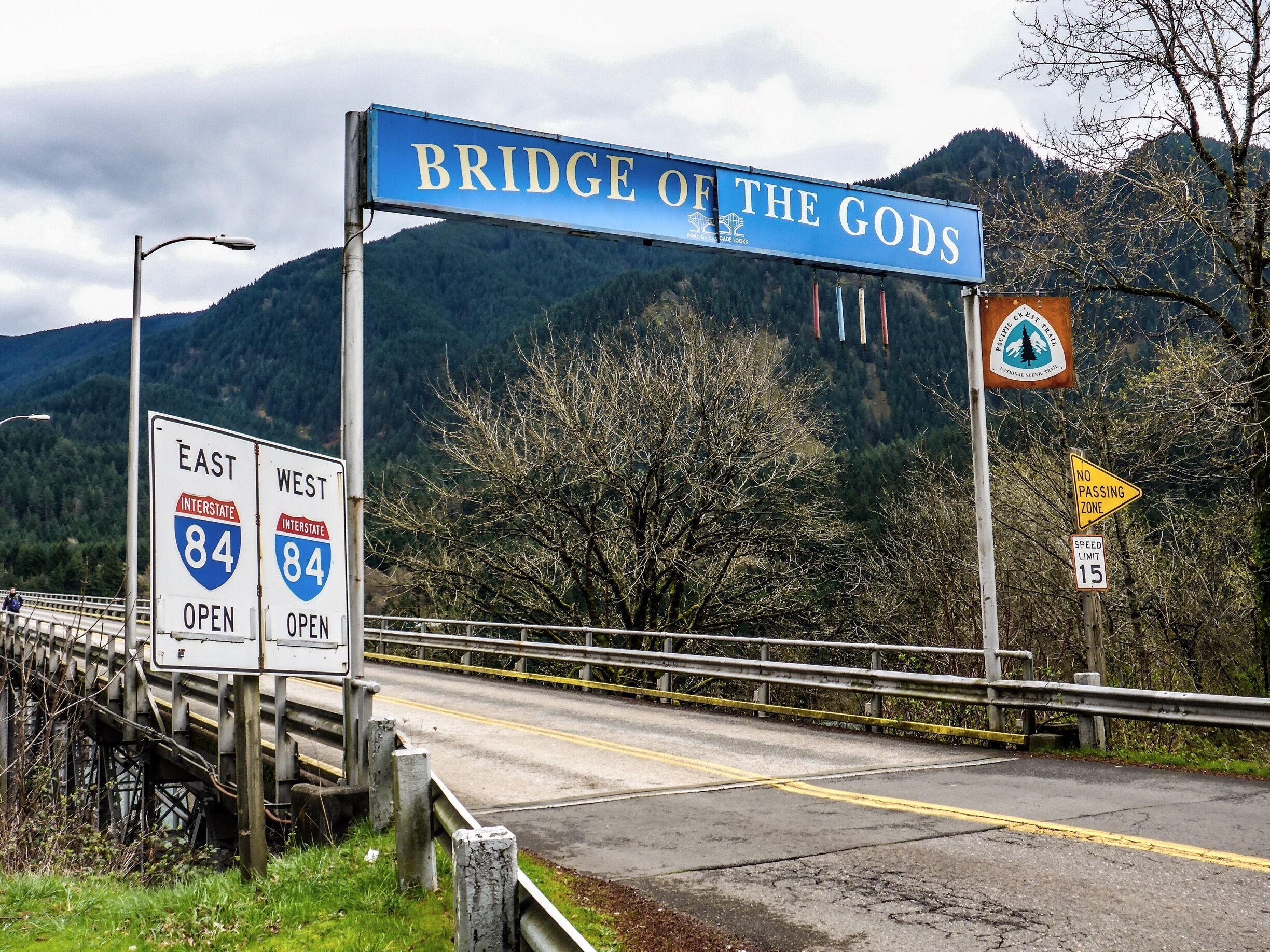 A road sign for the Bridge of the Gods with Interstate 84 East and West directions.