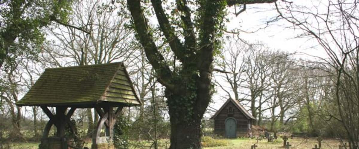 A cemetery with a wooden structure and a small building.