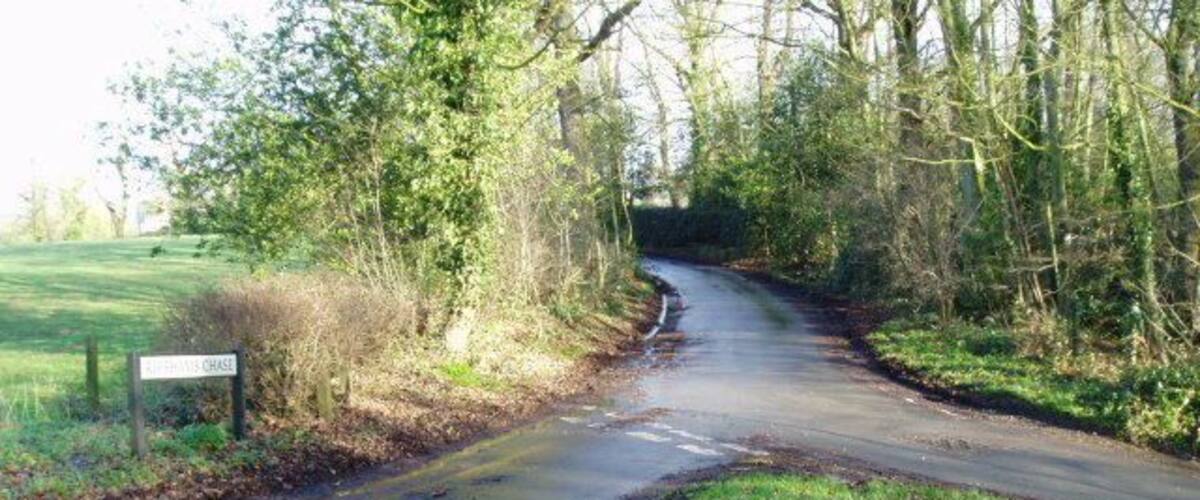 A narrow rural road with a sign reading "HAYWOOD CHASE."