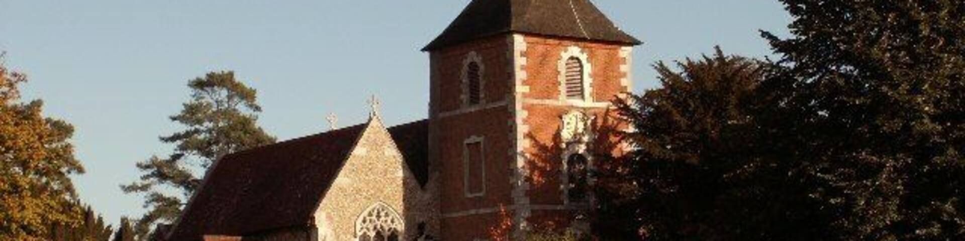 A church with a tall spire and a smaller building with a red roof.