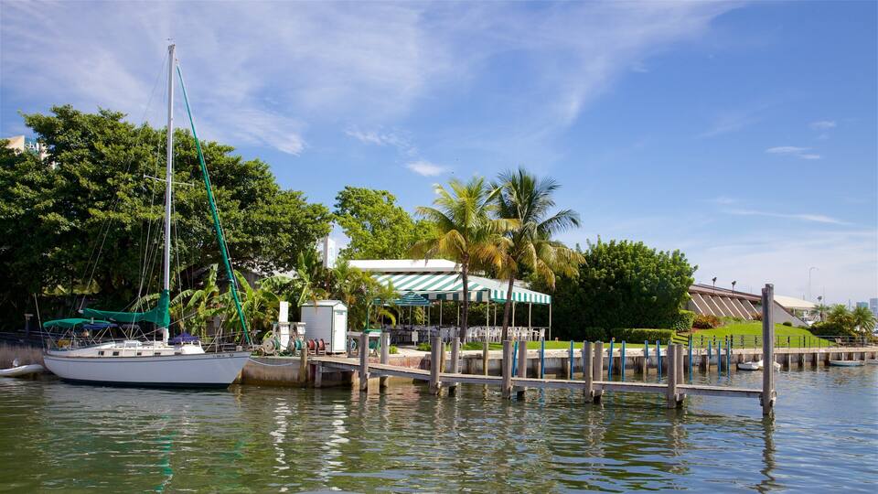 A marina with boats docked, a covered area, and lush greenery.